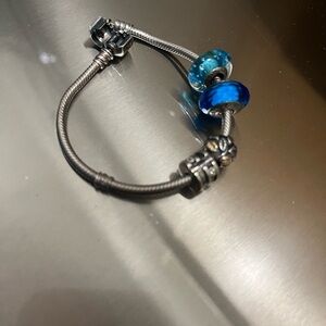 Pandora bracelet with 4 charms including circle of life charm.